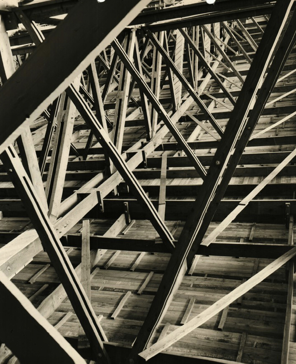 A close-up view of the damaged condition of the wood trusses and the wood roof planks inside Hangar 3.