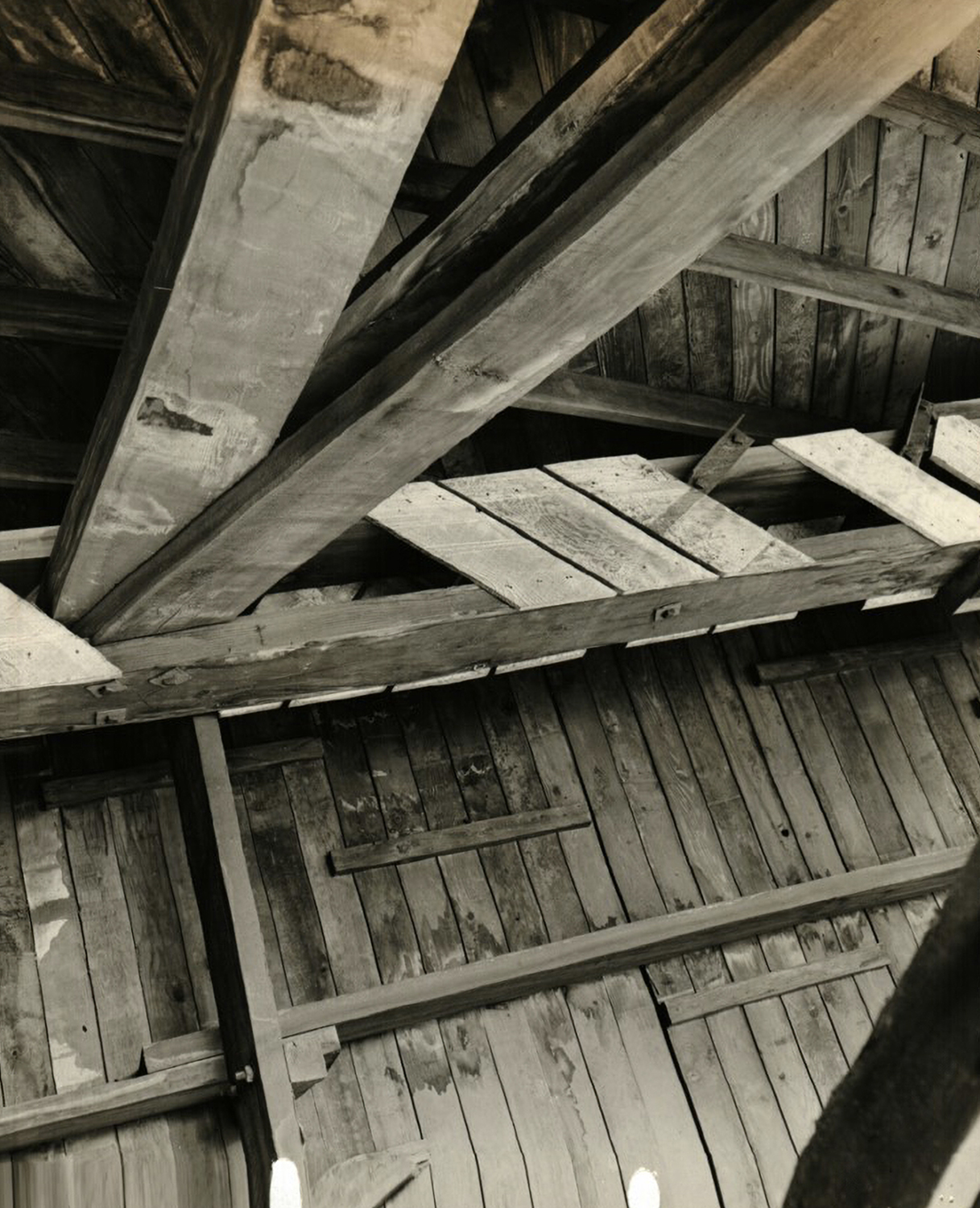 A close-up view of the damaged condition of the wood trusses and the wood roof planks inside Hangar 3.